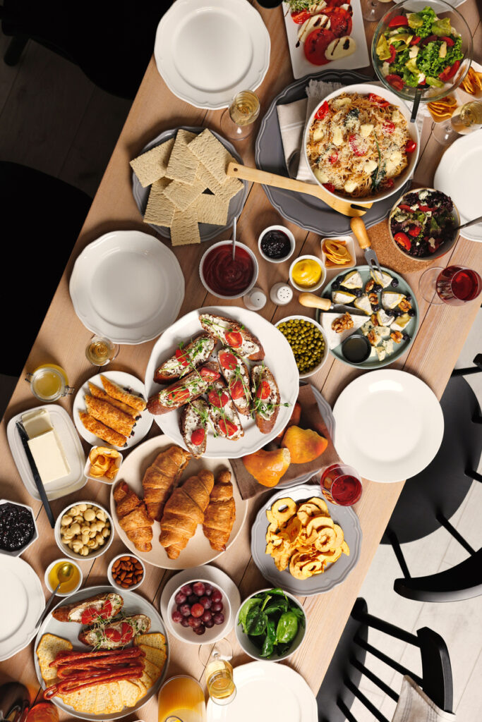 Brunch table setting with different delicious food and chairs indoors, top view Brunch table setting with different delicious food and chairs indoors, top view